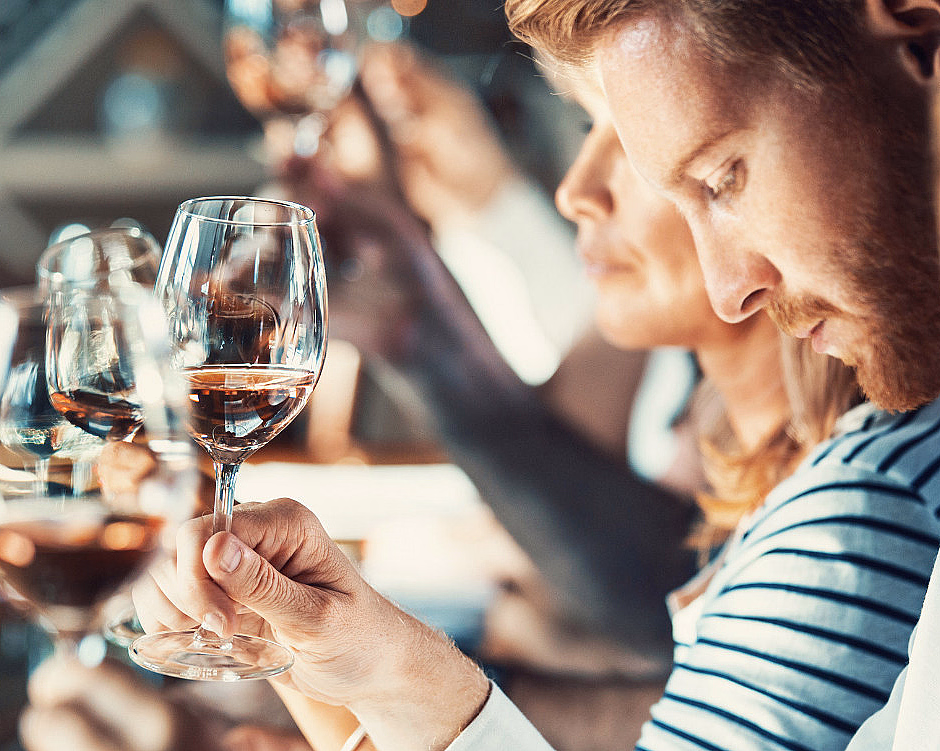 Personer som studerer og lukter på glass med rosevin under en vinsmaking