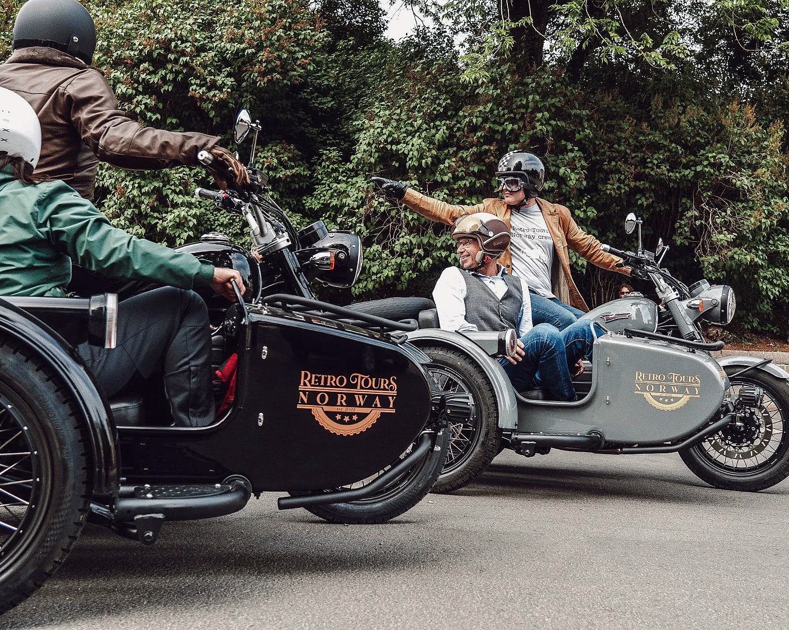Tre personer på motorsykler med sidevogner merket Retro Tours Norway på en vei