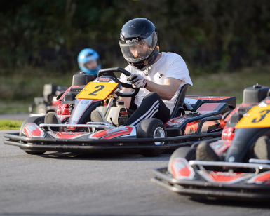 Mann med hjelm kjører gokart på en bane