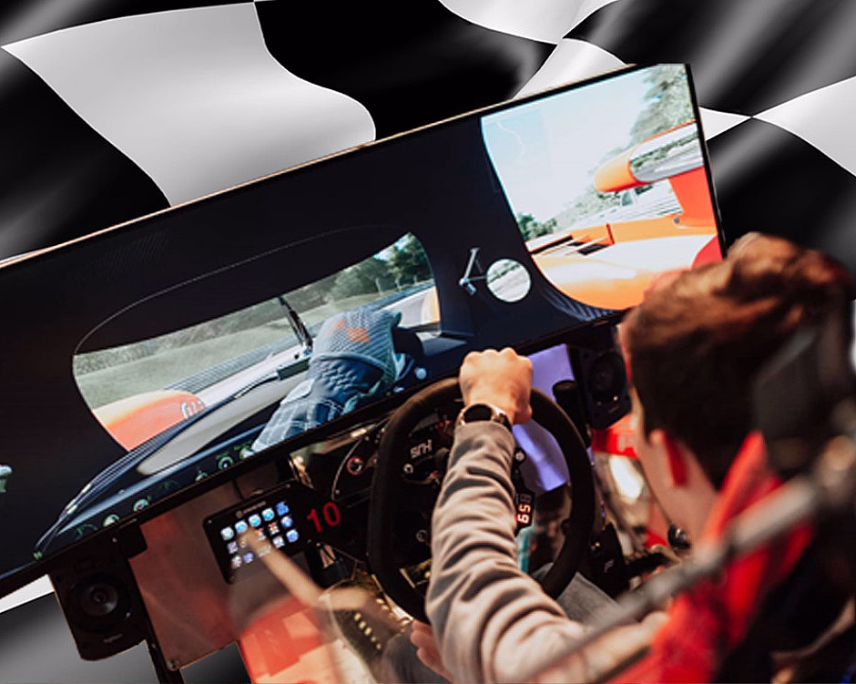 Person i en racingsimulator med ratt foran en skjerm med bilspill og rutete bakgrunn