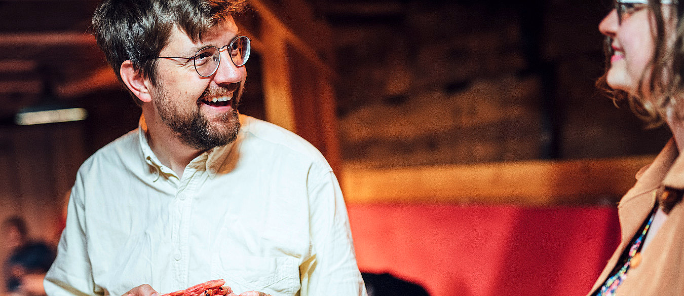 To personer smiler og holder hver sin tallerken med mat