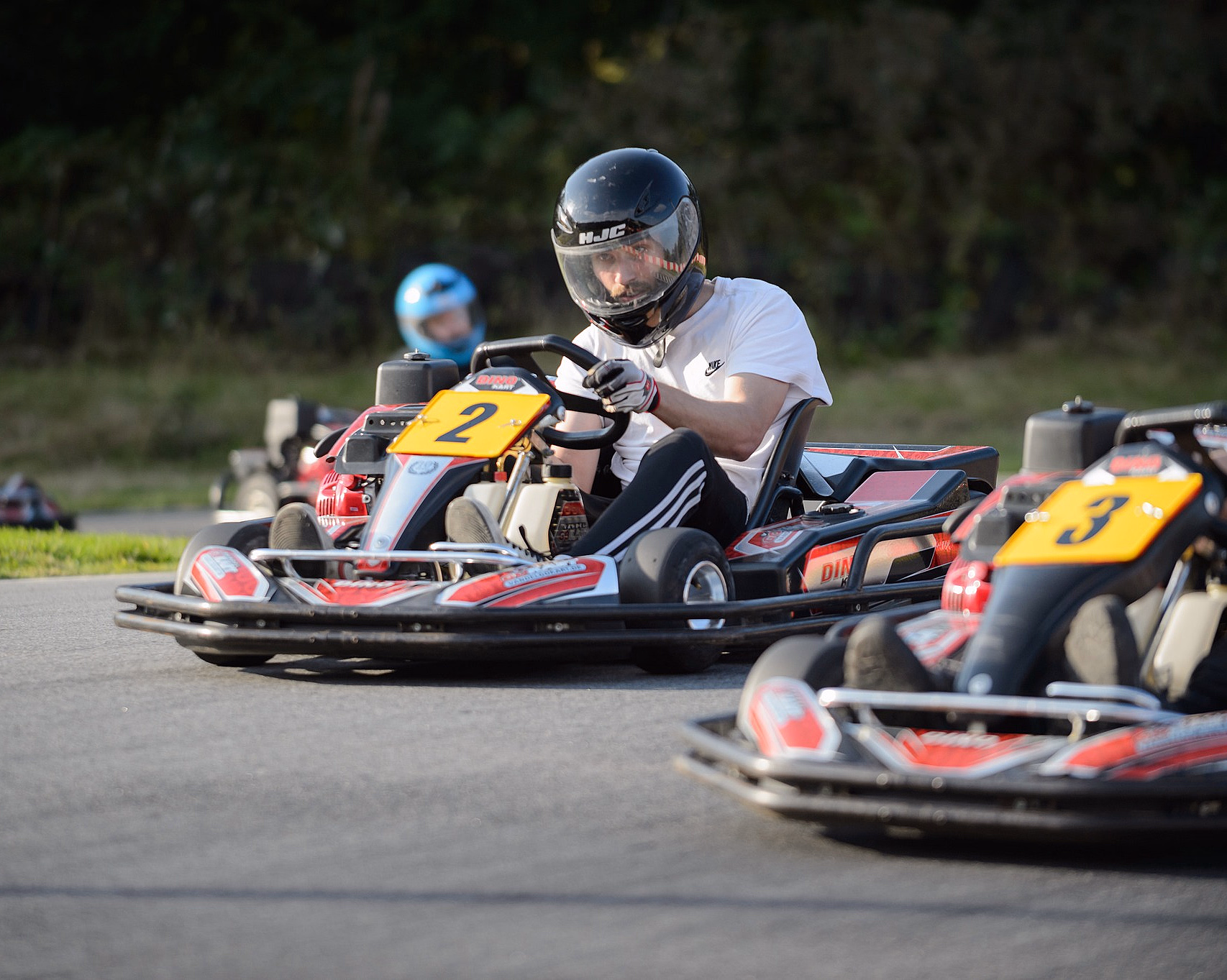To personer kjører gokart på en utendørsbane