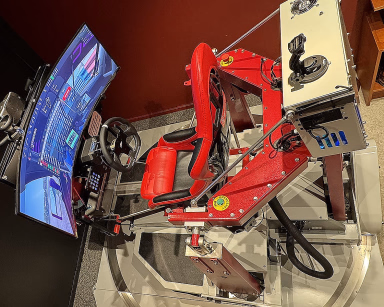 Avansert racingsimulator med rødt sportssete, ratt og en buet skjerm på en bevegelig plattform