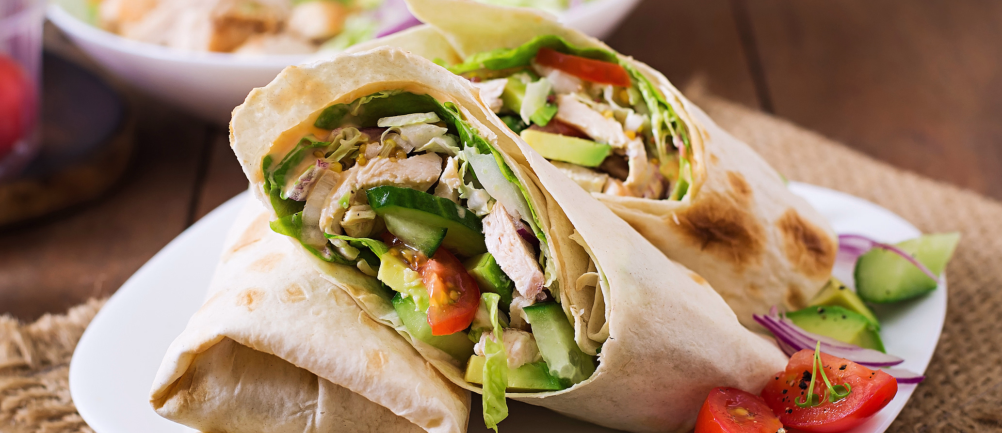 To wraps med kjøtt og grønnsaker på en hvit tallerken
