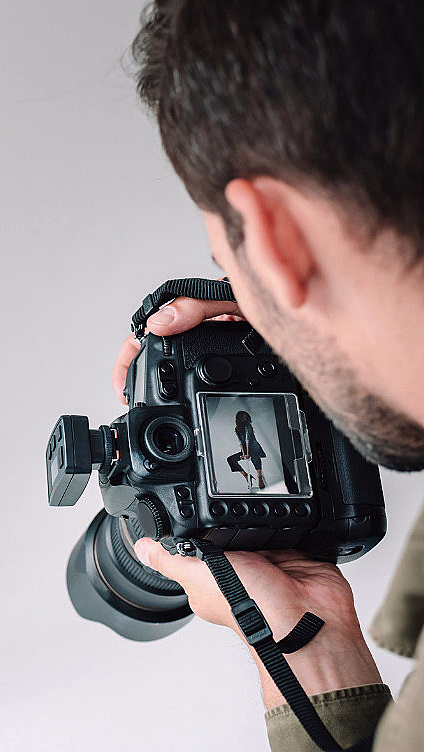 Fotograf som tar bilde av en kvinne i et fotostudio