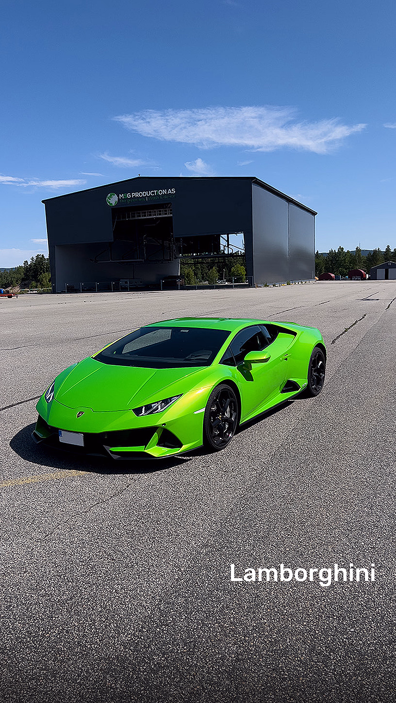 Grønn Lamborghini parkert på en asfaltert bane foran en stor grå hangar