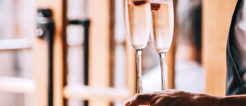 En hånd som holder to glass med musserende vin