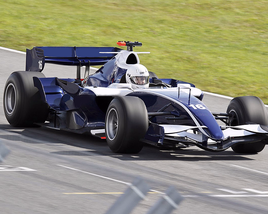 Blå og hvit formel 1-bil med nummer 16 i fart på en racerbane.