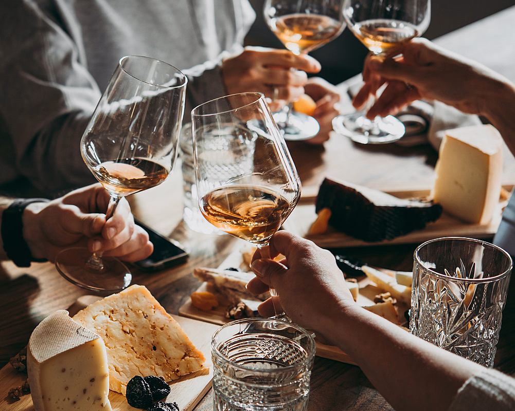 Marmoroverflate med en champagneflaske, en innpakket gave med teksten "Til deg!", et tastatur med et gavekort, en dagbok og eukalyptusblader.