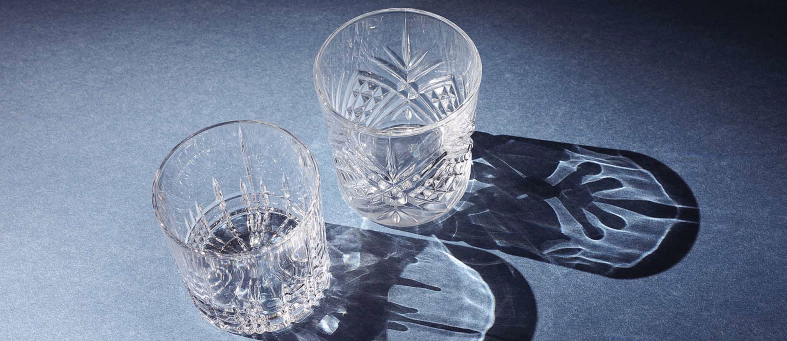 To krystallglass med mønster som kaster skygger på en blå bakgrunn
