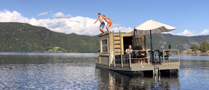 To gutter som skal hoppe i vannet fra taket på en husbåt
