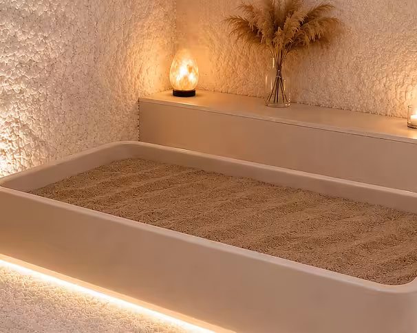 Oppvarmet sandbad i et rom med saltvegger, saltlampe og tørket prydgress