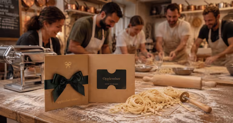 Folk i forkle lager pasta bak et gavekort med teksten Opplevelser