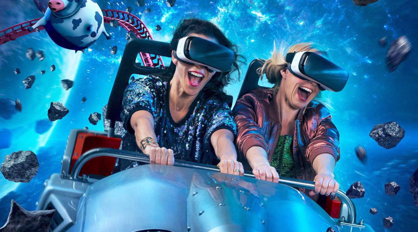 To personer med VR-briller på en berg-og-dal-bane i verdensrommet med en tegneserieku