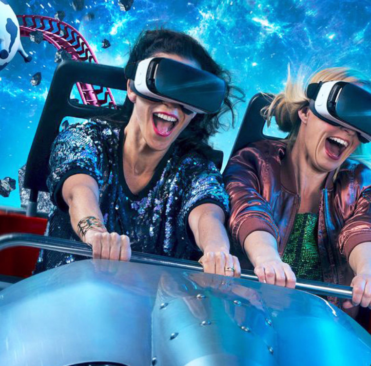 To personer med VR-briller på en berg-og-dal-bane i verdensrommet med en tegneserieku